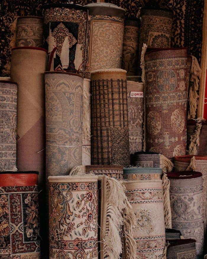 A vertical display of various intricately designed oriental rugs stacked in a store.